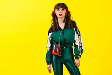 Cheerful Gorgeous Girl In Clothes In The Style Of The 90s, With A Vintage Cassette Player And Headphones, In The Studio On A White Background. Music, Emotions, Fashion