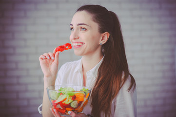 Beautiful girl eats fresh salad at home