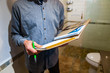© Valmedia - inspector holding a notebook, pen and his glasses as he checking the bathroom and shower, home checking and inspecting, interior inspection concept