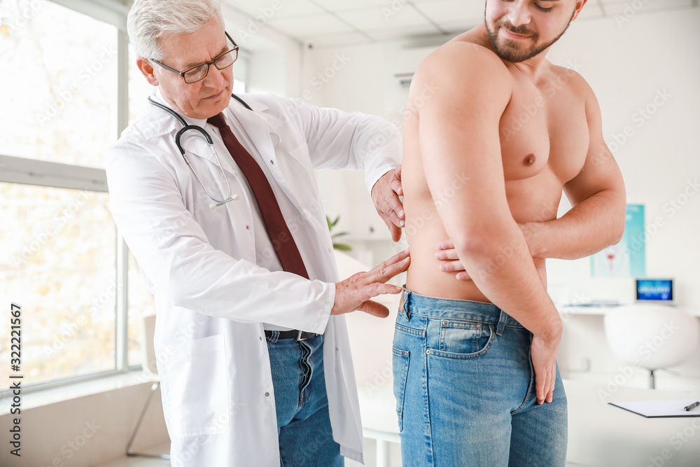 Urologist examining young patient in clinic