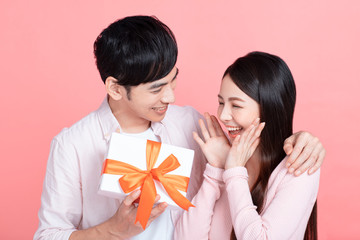 Happy young couple  celebrating  valentines day and  holding gift box