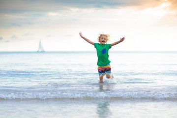 Wall Mural - Kids play on tropical beach. Sand and water toy.