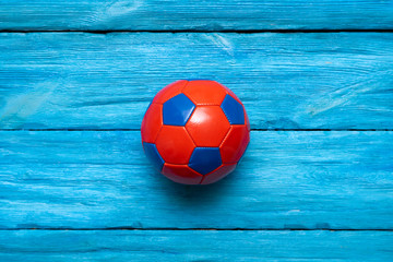 Wall Mural - Small soccer ball on the blue wooden table background.