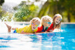 © famveldman - Kids in swimming pool. Children swim. Family fun.