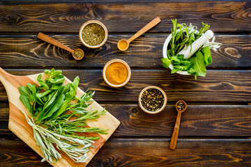 Wall Mural - Herbs and spices on dark wooden kitchen desk top-down