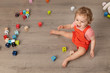 © Lisa Tichané - Laughing baby sitting on floor playing with alphabet blocks