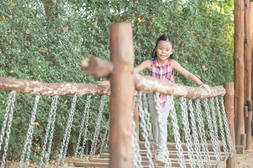 happy little asian girl child having fun to playing in the playground in summer time with smile and laughing healthy, funny smiling face adorable lovely female kid. happy vacation lifestyle concept.