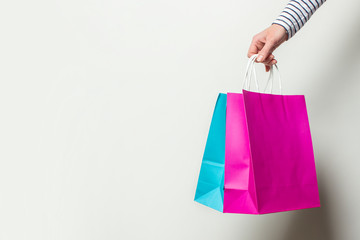 Female hand holds shopping bags on a white background. Concept shopping, discount, sale. Banner