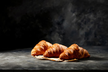 Sticker - Dark mood background and fresh croissants on board.Free space for your decoration and breakfast time. 