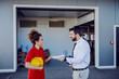 © Dusan Petkovic - Young caucasian graphic engineer giving paper with tasks to his female employee. They are standing in front of print shop.