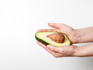 Wall Mural - Avocado in hand on white background. Vegetarian food and vitamins