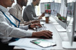 © Svitlana - Every stock broking matters. Cropped shot of three businessmen sitting at desktop front PC computers with financial graphs and statistics on monitors. Analysis of digital market and investment