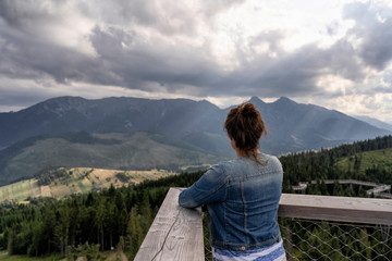 Young woman enjoying view of dramatic mountains. Selective focus. High Tatras, Slovakia.