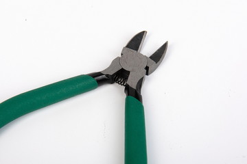 Metal tool pliers with green handle on white background