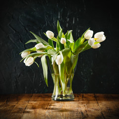 Fotomurales - Dark mood background and fresh flowers of tulips.