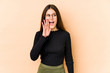 © Asier - Young caucasian woman isolated on beige background shouting excited to front.