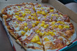 Pizza Hawaii in einer Schachtel in schräger Aufnahme