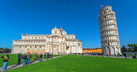 Wall Mural - Pisa, Tuscany, Italy - February 3, 2020: Piazza dei miracoli of Pisa. Travelers admire architecture of the Cathedral and  the iconic leaning tower of Pisa. Clear Blue sky