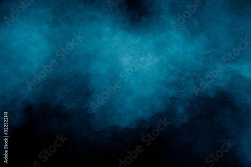 Cuadros en Lienzo Blue color dust particles explosion cloud on black background