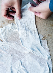 Wall Mural - man working with fabric soaked in wet plaster