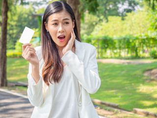 asia happy business woman holding blank card stand in park