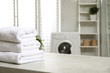 Stack of clean towels on table in laundry room. Space for text
