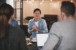 © Flamingo Images - Smiling Asian businesswoman talking to coworkers during a meetin