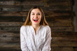 © Вячеслав Чичаев - nice brunette girl with long hair with a smile in a white shirt laughs merrily on a wooden background and shows positive emotions