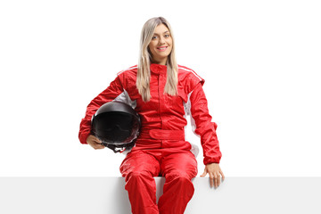 Poster - Female racer in a suit holding a helmet and sitting on a panel