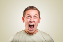 An Angry Young Man Screams On A Yellow Background.