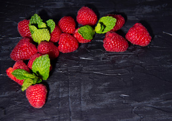 Raspberries on black background. Fresh ripe sweet berries. Selection of healthy food. Slate banner background.