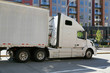 A large truck with a semi trailer in city traffic. A city on the east coast of the USA.