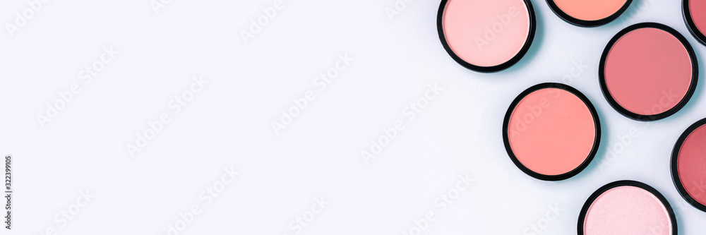 Pink blush and compact powder on a pastel blue background. Banner. Place for text, design. Top view.  Trending colors. Makeup. Cosmetic products. Tonal foundation. Flat lay, Layout. Beauty concept.  - obrazy, fototapety, plakaty 