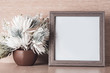 Square photo frame and white flowers on a light wooden background , place for text