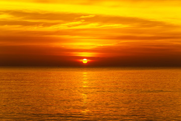 Wall Mural - sunset with large yellow sun under the sea surface