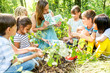 © Westend61 - School children learning to recognize plants in nature