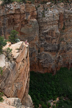 Girl Dangling Her Legs Off A Sheer Sandstone Cliff