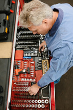 High Angle View Of Mechanic Selecting Tool From Toolbox In Automobile Workshop