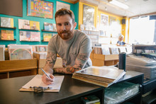 Portrait Of Man Working In Independent Record Store And Making Notes