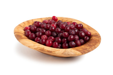 Poster - Ripe cranberries in a bowl of olive wood isolated on white background