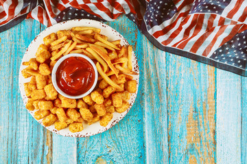 Wall Mural - French fries and tater potato on wooden table for american holiday.