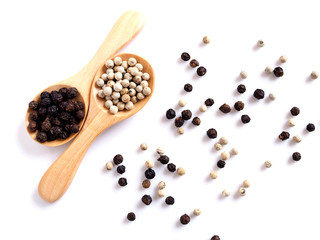 Dried food whole grains with black pepper and white pepper in wooden spoon isolated on white background.