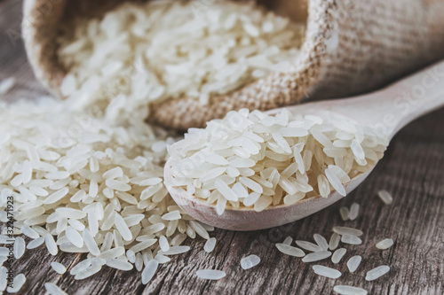 Fotomural White rice scattered from a bag on a background of old boards