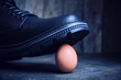 Black boot steps on a fragile chicken egg. Concept, weak defenseless, care and custody.