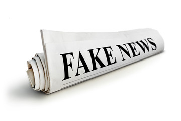 concept of false news. Rolled Up Newspaper with Headline of Fake News Isolated on White Background.