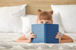 © Pixel-Shot - Cute little girl reading book at home