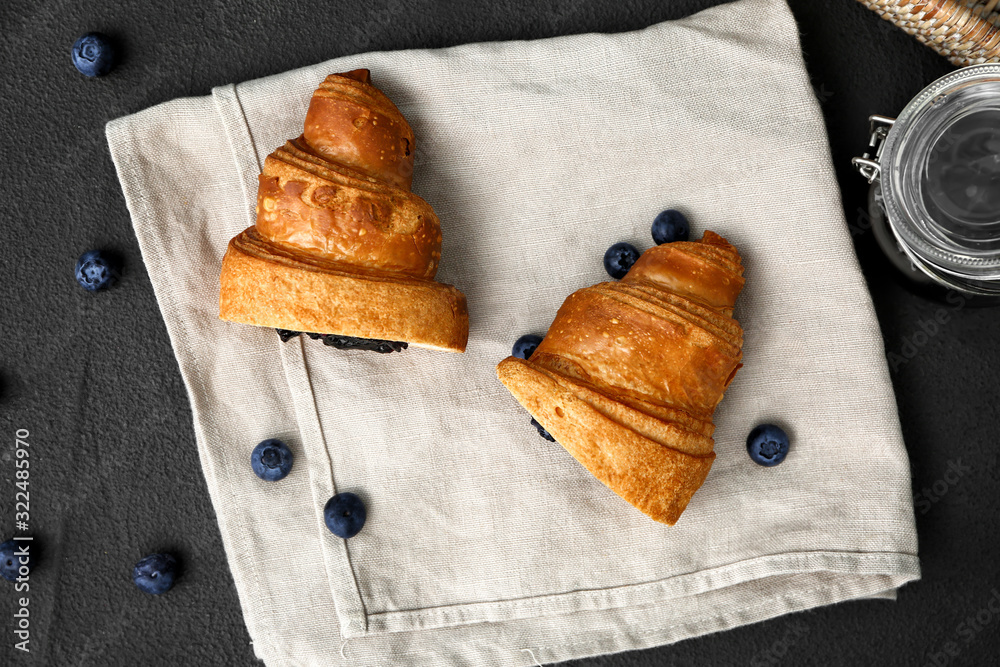 Tasty sweet croissant with jam on dark background