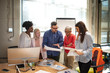 © Dragana Gordic - Young happy entrepreneur talking to his colleagues during a business meeting in a board room. Mid adult businessman talking to his colleagues on presentation in the office