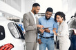 Salesman Offering Couple A Car Standing In Auto Rental Office