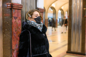 Wall Mural - young european woman in protective disposable medical black mask in metro. concept protection of dangerous 2019-nCoV influenza coronavirus, mutated and spreading in China